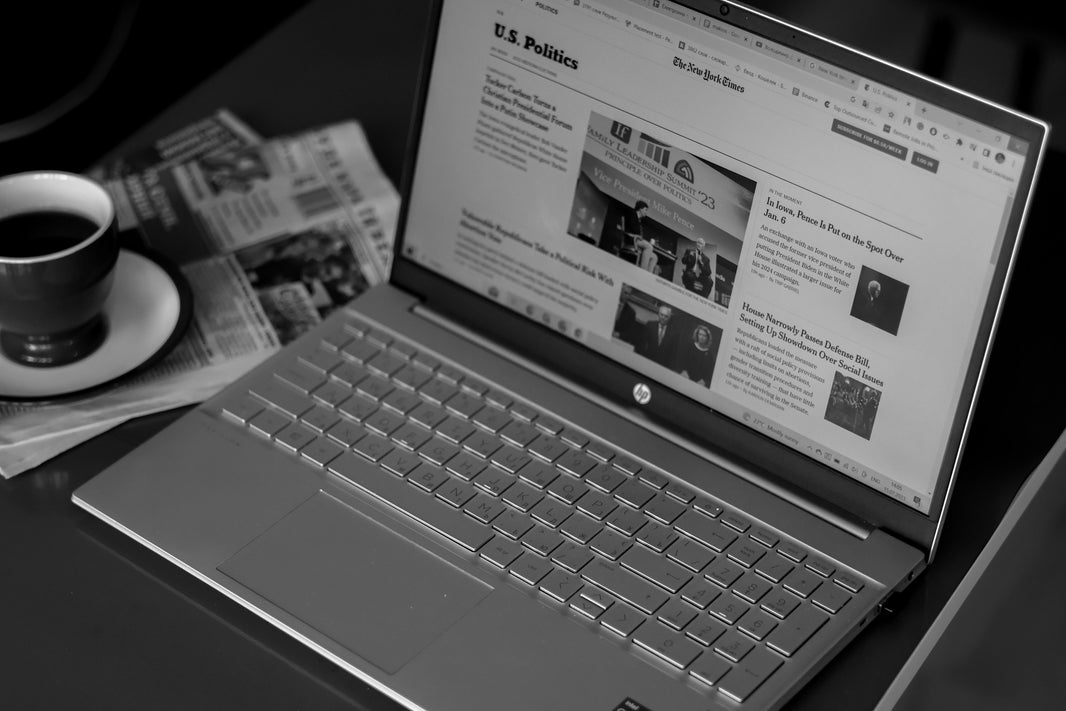 black and white laptop next to coffee cup