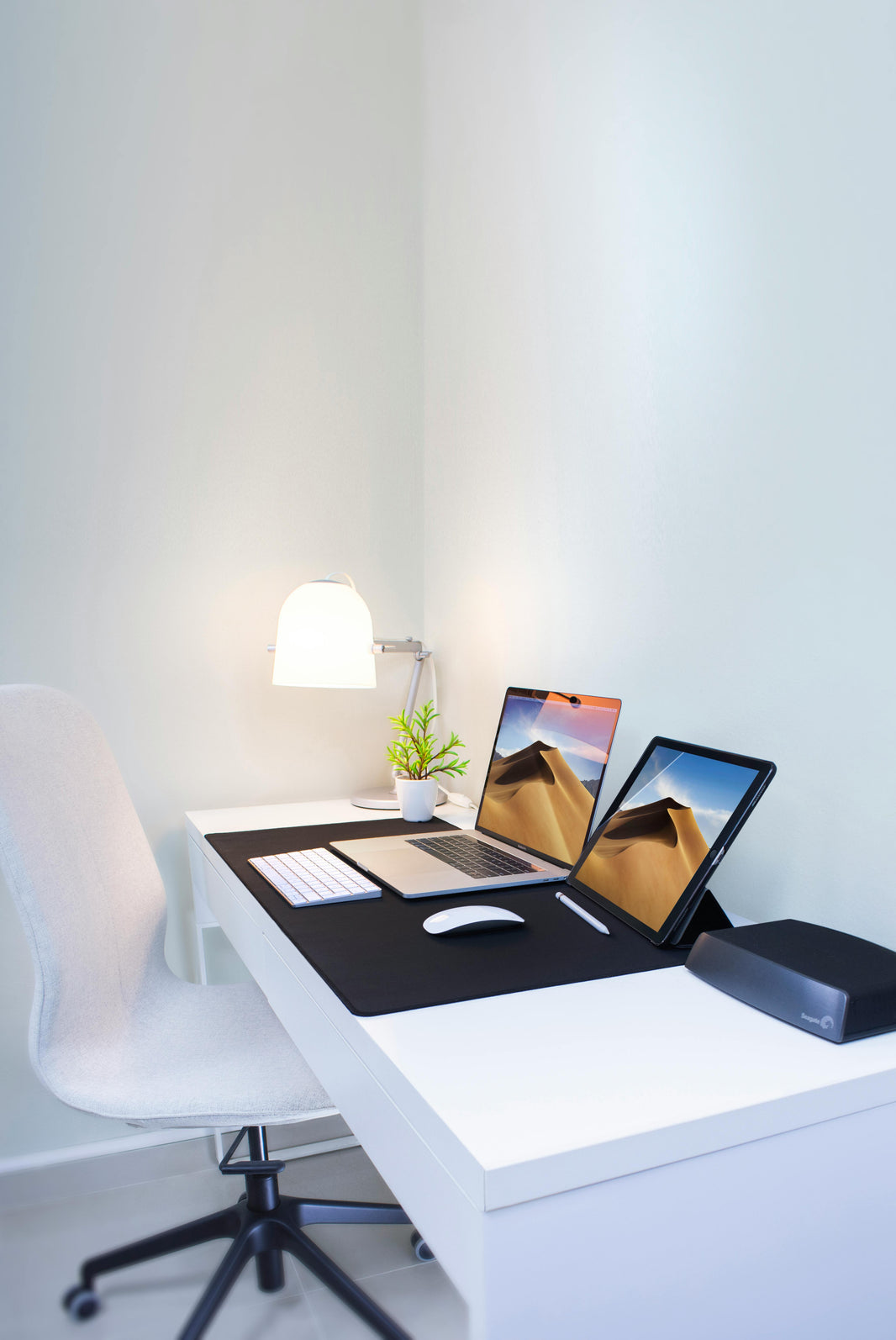 laptop and tablet open at white desk