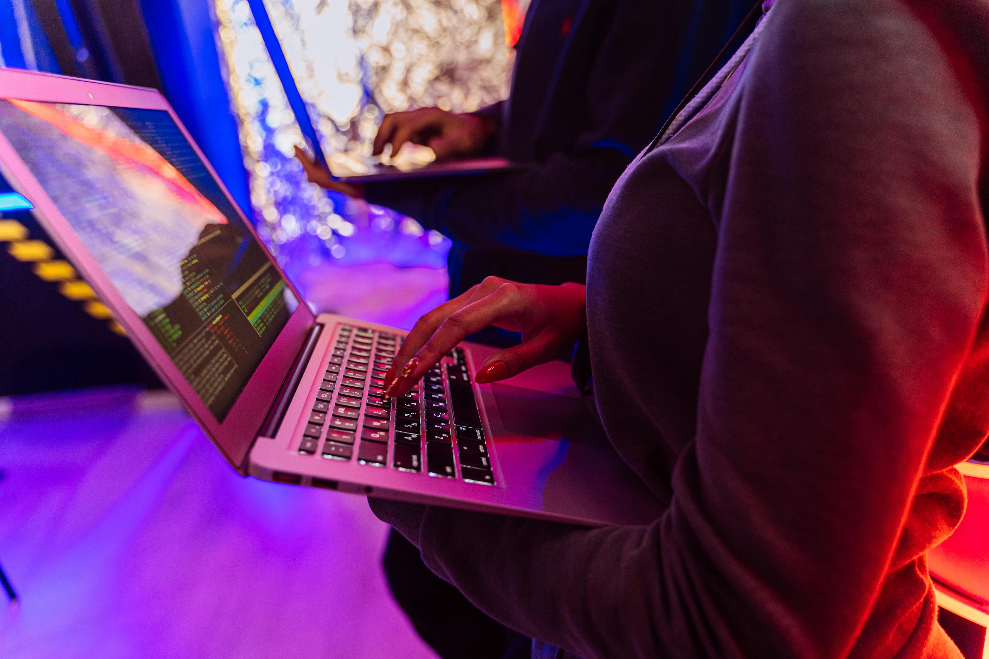 two people typing on laptops