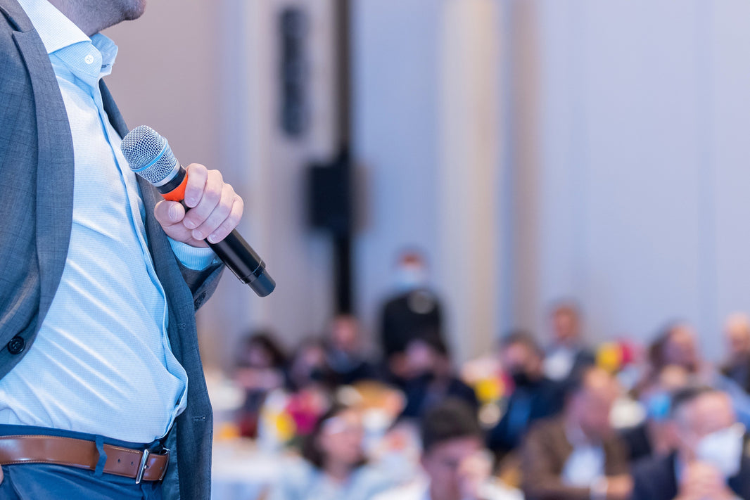 man with microphone in front of crowd