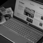 black and white laptop next to coffee cup