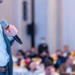 man with microphone in front of crowd