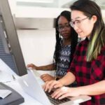 two employees working on laptop